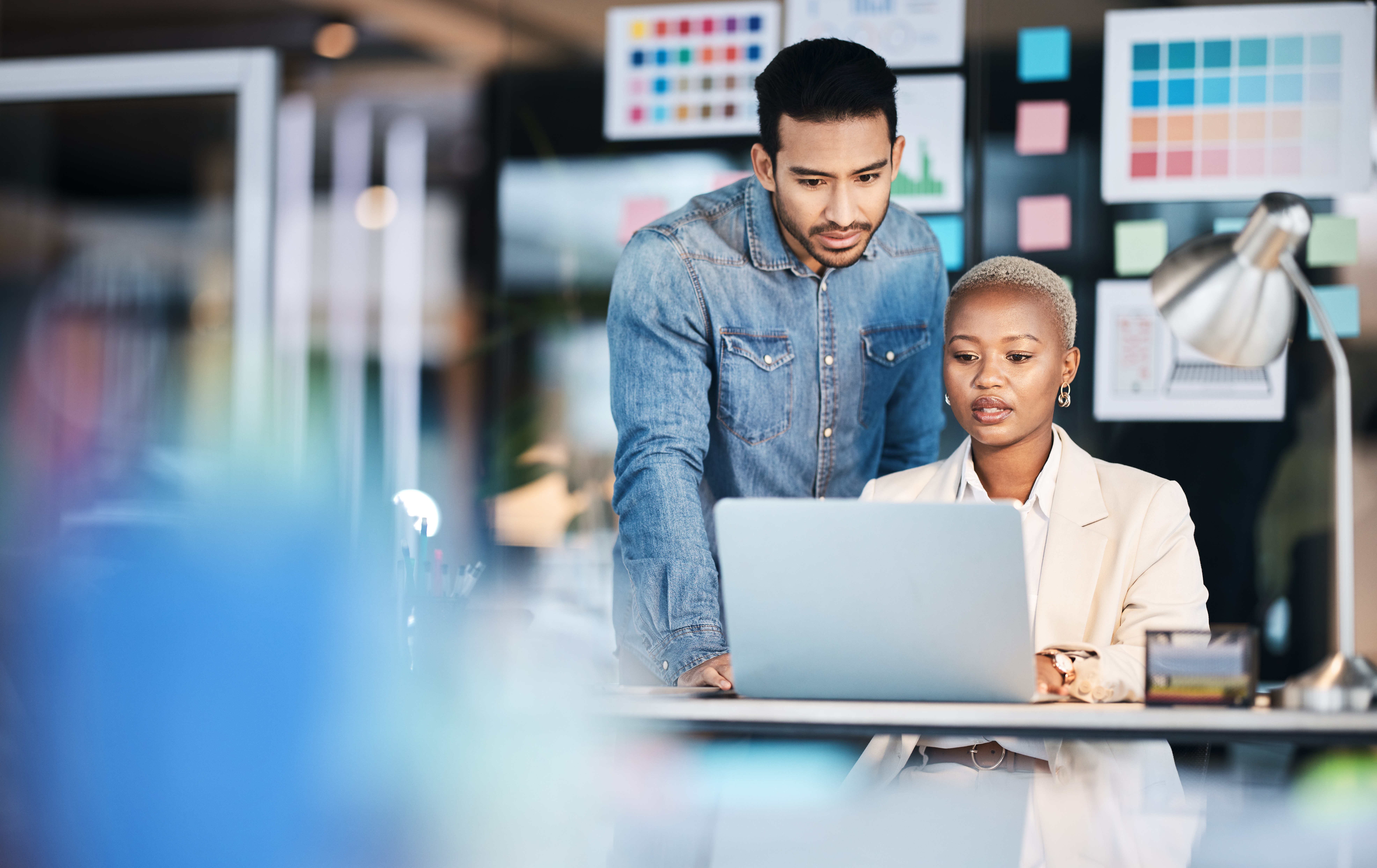 Laptop, designer collaboration and business people reading, problem solving and working on creative design deadline. Diversity partnership, startup teamwork and professional team review research plan.